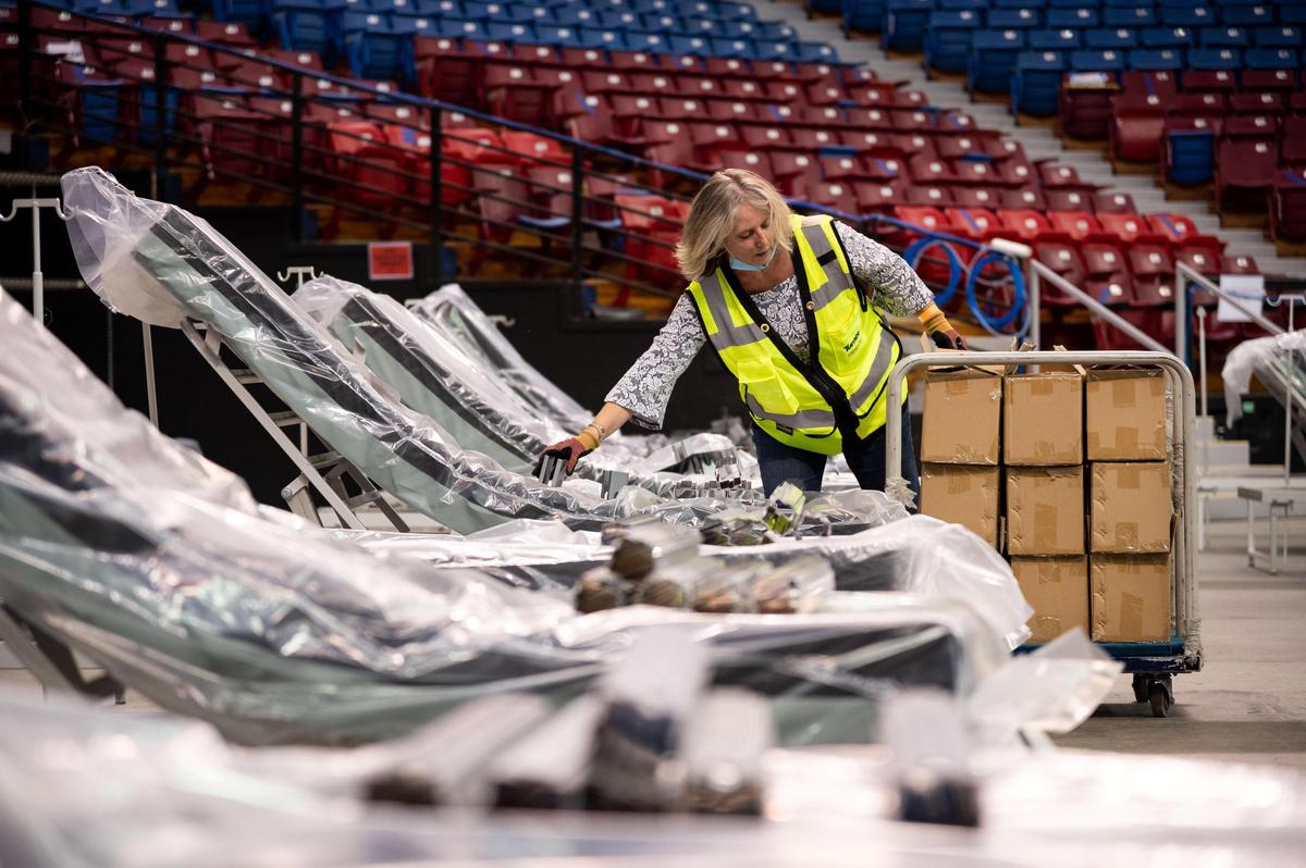 Diana Tibor, California Department of General Services project director and manager for the buildout at the Sleep Train Arena alternative care facility, works Saturday, April 18, 2020, in preparation for opening Monday as a surge facility to combat COVID-19 in the Sacramento region.