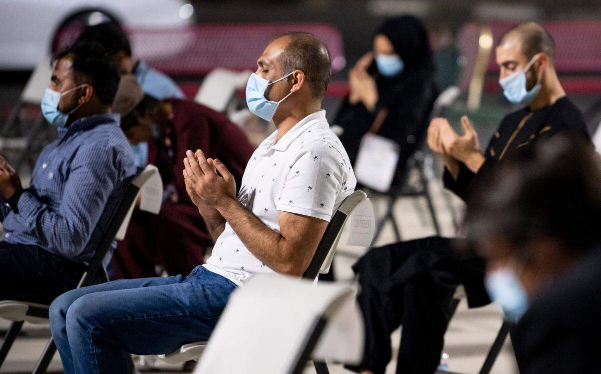 Qais Jalal, left, center, brother of 27-year-old shooting victim Shujauddin Omarkheil, an American River College student who was shopping with his 4-year-old daughter when he was killed, prays during an event remembering the victims at the Masjid Annur Islamic Center on Wednesday, Oct. 14, 2020, in south Sacramento.