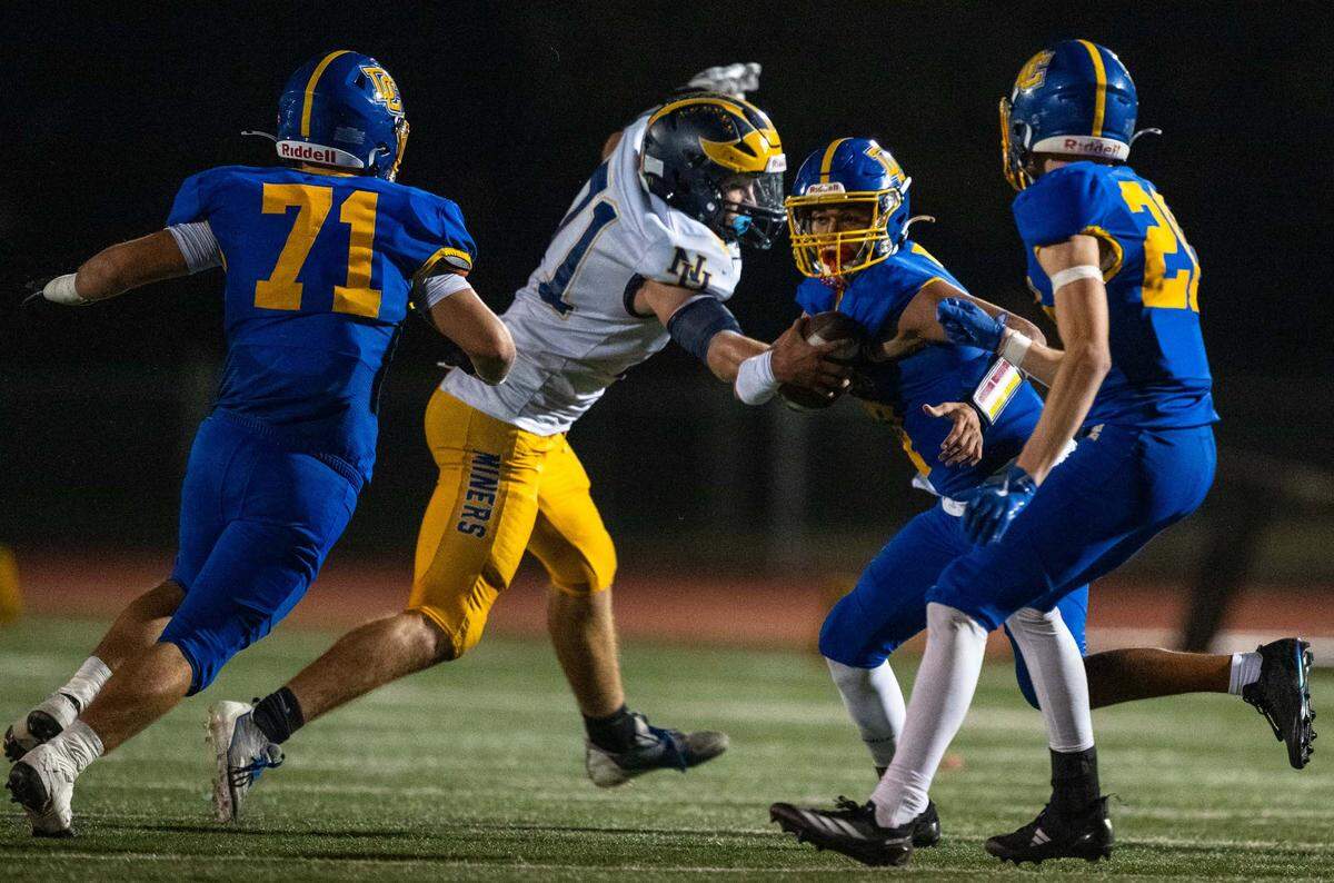 Nevada Union Miners defensive lineman Craig Statler (71) grabs Del Campo Cougars quarterback Angel Reyna (7) for a sack in the second half on Friday.