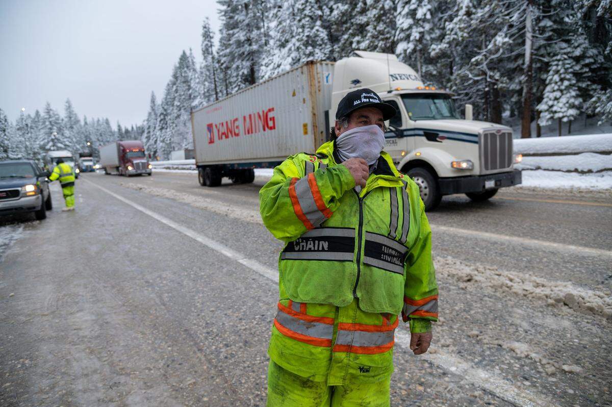 Chris Lotito, 66, installs chains on vehicles traveling eastbound along I-80 on Wednesday, Jan. 27, 2021, in Placer County. He said has been installing chains for 43 years.