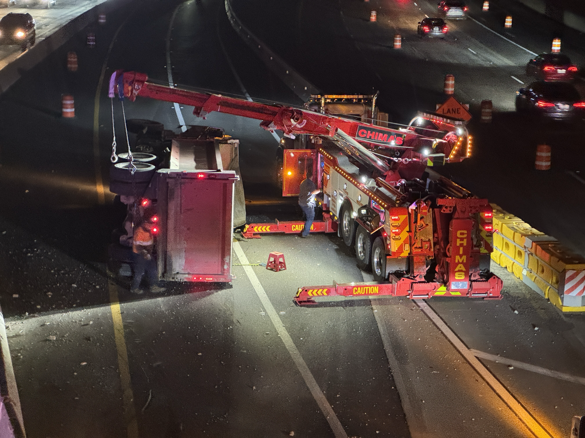 A tow truck crane works to upright a dump truck that was stolen from Roseville and crashed on Highway 50 in East Sacramento after leading law enforcement on a chase across several freeways on Wednesday, Dec. 17, 2025.