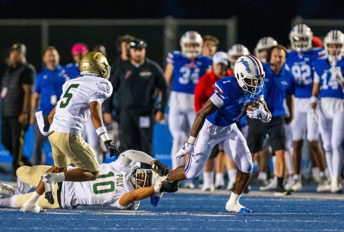 Folsom Bulldogs’ Carter Jackson (1) escapes the Long Beach Poly Jackrabbits’ Legend Galeai (10) for a first down on Friday, Aug. 23, 2024, in Folsom.