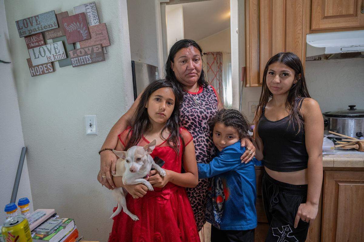 Marcella Parks, 45, and her three children, who all have disabilities, from left, Angel Guevara, 9, David Guevara, 7, and Ceralanie "CJ" Martinez, 15, stand Tuesday in the kitchen of a city-funded cottage where they have lived since January at Arden Acres in Sacramento. The city is changing the program, and when Parks went to move her family into a hotel arranged by the city, she was told no rooms were available.
