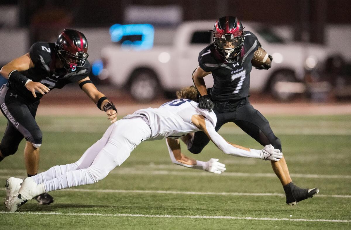 Woodcreek Timberwolves running back Dylan Perrault (7) runs for a gain before being taken down by Inderkum Tigers defensive back Lono Chouteau (18) during the second quarter of the high school football game Friday, Sept. 22, 2023, at Woodcreek High School in Roseville.