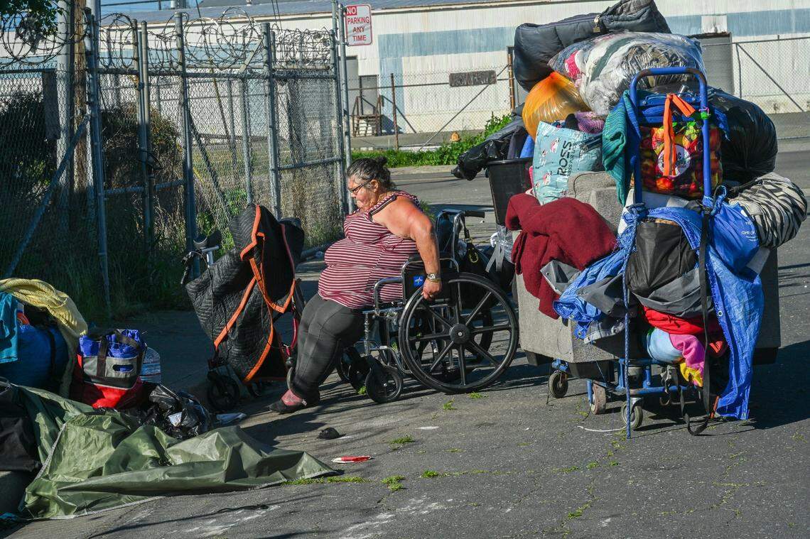 Theresa Rivera, 45, who is homeless and uses a wheelchair because a leg infection prevents her from walking, packs her belongings onto a cart in March after receiving a citation to move from N. 14th St. in Sacramento’s River District. Earlier that morning police came with city workers and swept the area with bulldozers, taking her clothes, soap and pots and pans.