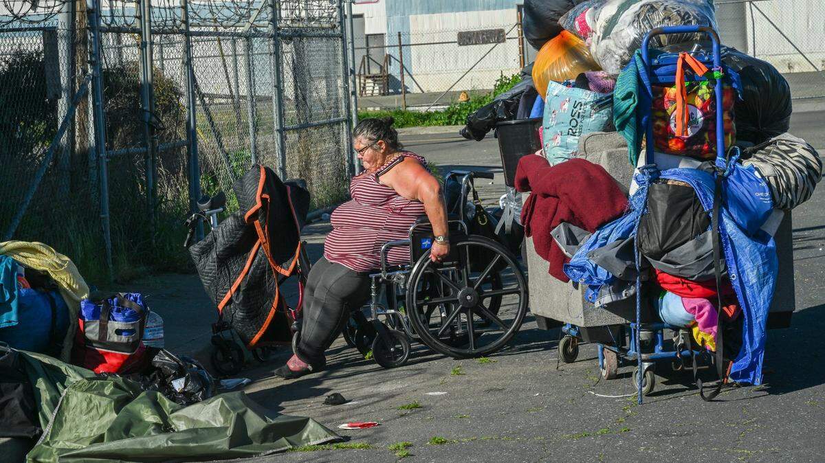 Theresa Rivera, 45, who is homeless and uses a wheelchair because a leg infection prevents her from walking, packs her belongings onto a cart on Wednesday, March 13, 2024, after receiving a citation to move from N. 14th St. in Sacramento’s River District. Earlier that morning police came with city workers and swept the area with bulldozers, taking her clothes, soap and pots and pans. She said she didn’t know where she would go.