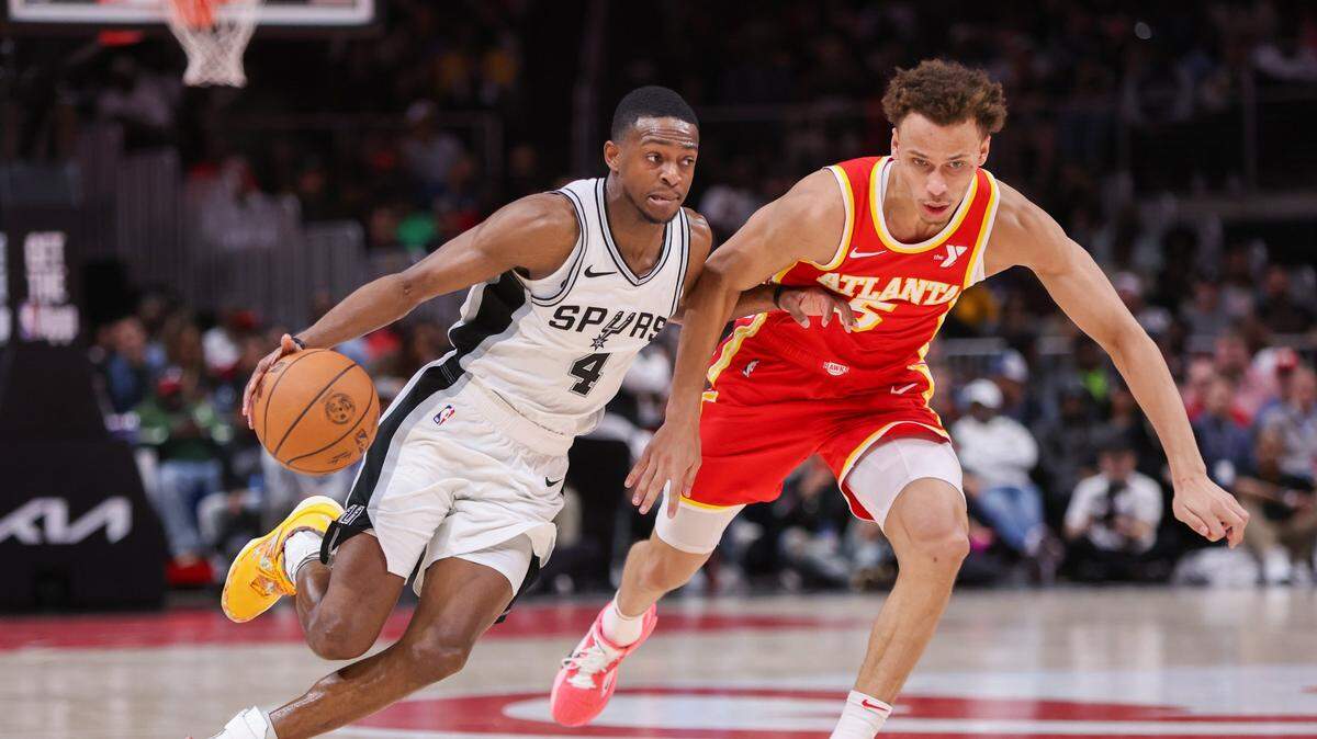 Feb 5, 2025; Atlanta, Georgia, USA; San Antonio Spurs guard De'Aaron Fox (4) drives past Atlanta Hawks guard Dyson Daniels (5) in the third quarter at State Farm Arena. Mandatory Credit: Brett Davis-Imagn Images