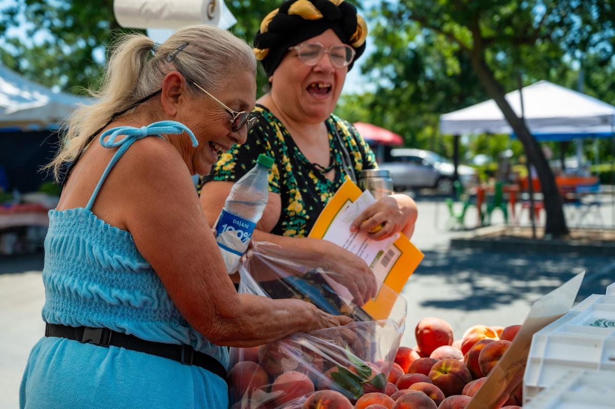 Mother and daughter Gloria Carter and Melody Couch pick out peaches to make a pie at the Meadoview Farmers’ Market in Sacramento on June 23.