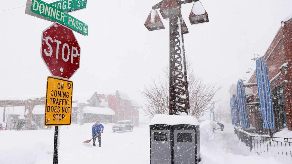 Nick Muzik shovels snow outside of the Bar of America as snow continues to fall in downtown Truckee in early March.