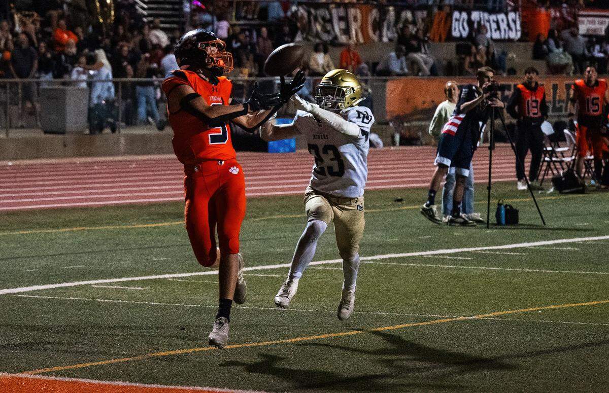 The Roseville Tigers’ Jack Walker (5) makes a 24-yard touchdown reception as the Nevada Union Miners' Owen Hooper (23) defends on Friday in Roseville.