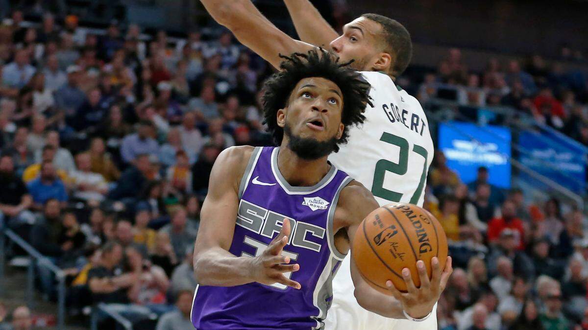 Sacramento Kings forward Marvin Bagley III, front left, goes to the basket as Utah Jazz center Rudy Gobert (27) defends in the first half of a preseason NBA basketball game Monday, Oct. 14, 2019, in Salt Lake City. (AP Photo/Rick Bowmer)