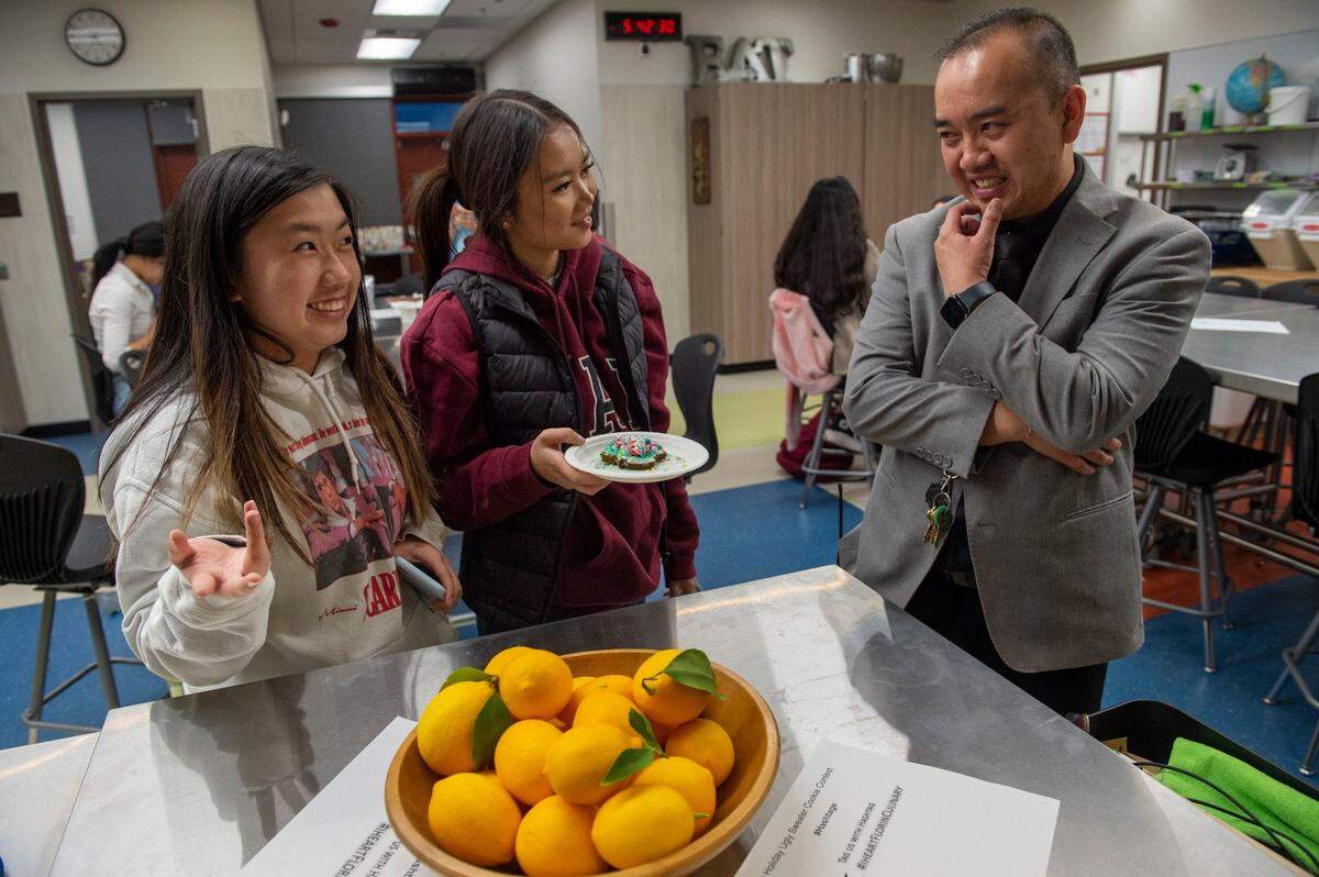 Neci Duong 17, left, and Brenda Lee, 15, show a Christmas cookie they made in an after school culinary class to Edward Lee, a vice principal at Florin High School who oversees the after school programs, on Thursday, Dec. 8, 2022.