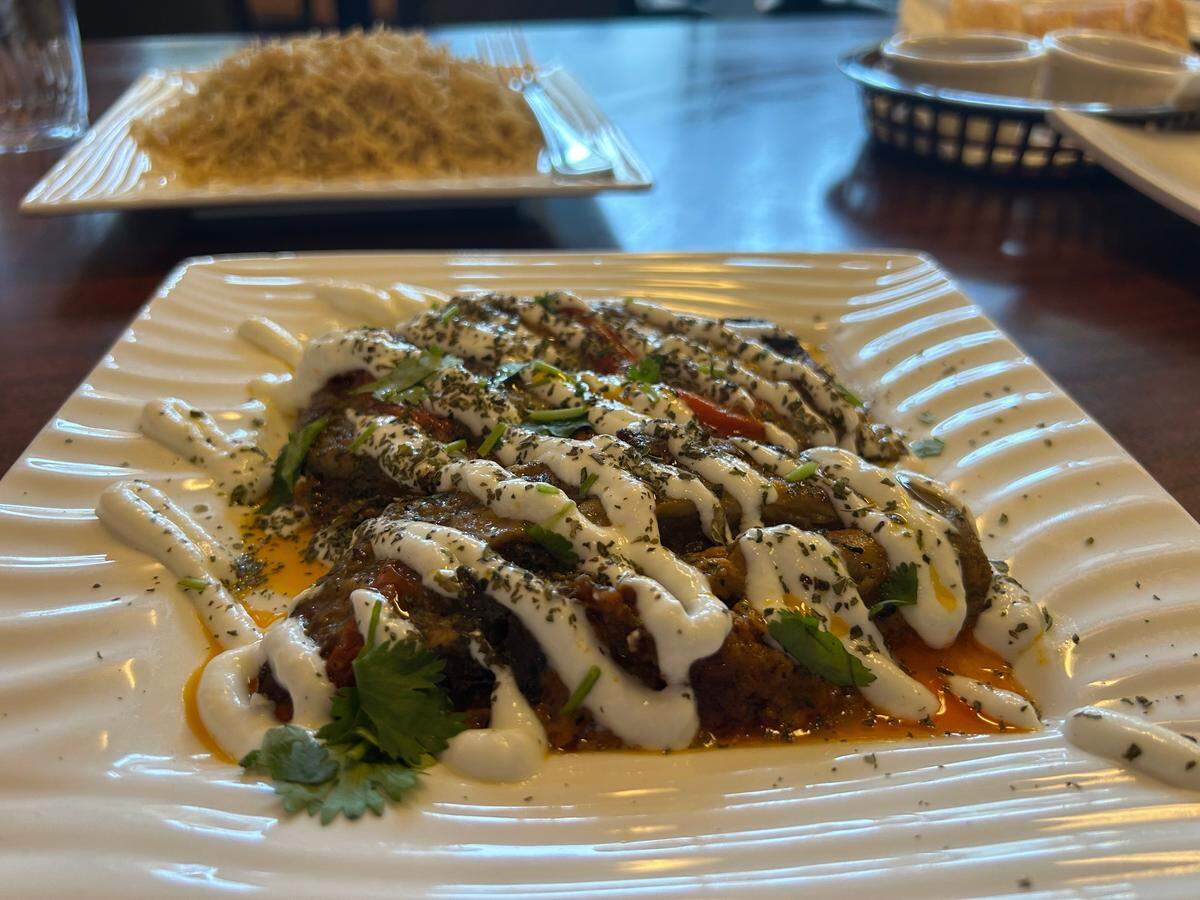 Borani badajan vege at Aria-Afghan Restaurant in North Highlands features baked eggplant topped with garlic yogurt and sprinkled with dried mint served with a hearty side of seasoned rice and bread.