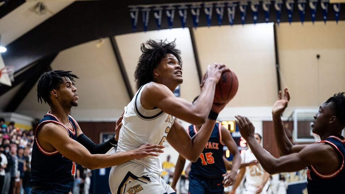 Elk Grove center/forward DaJon Lott Jr. (21) goes up to score as Cosumnes Oaks Brandon Hayward (1), left, and Ja’len Flenory defend during the first period of the high school boys basketball game Feb. 4, 2022, at Elk Grove High School. The Thundering Herd beat the Wolfpack 81-58 on senior night at home in Elk Grove.