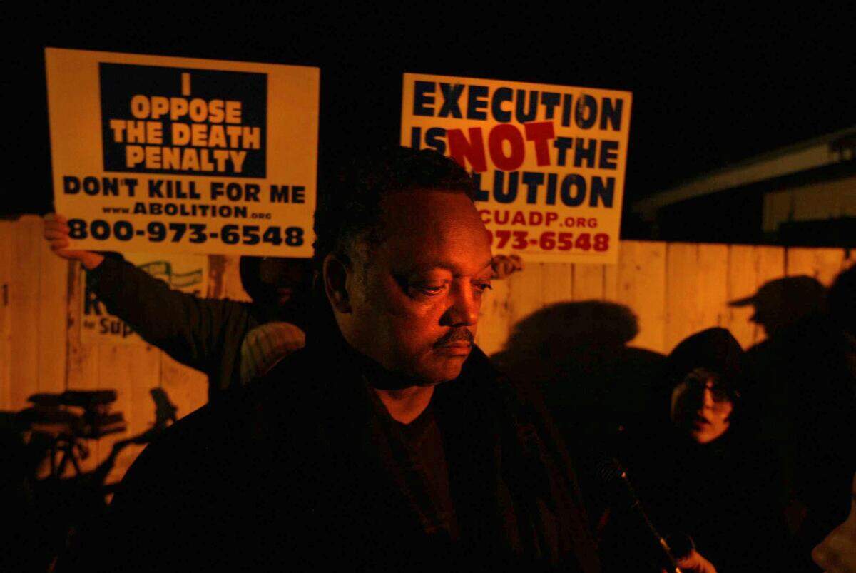 Rev. Jesse Jackson stands outside the gates of San Quentin Prison and talks to people protesting the death penalty on Feb. 9, 2004.