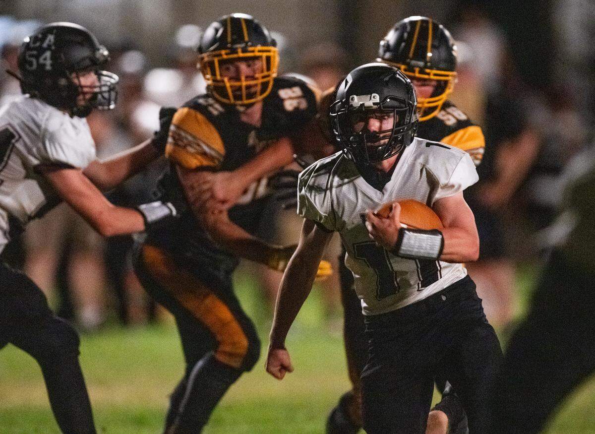 Valley Christian Lions quarterback Connor Tinker (11) runs on a keeper during the second half of an 8-man football game in Clarksburg on Friday.