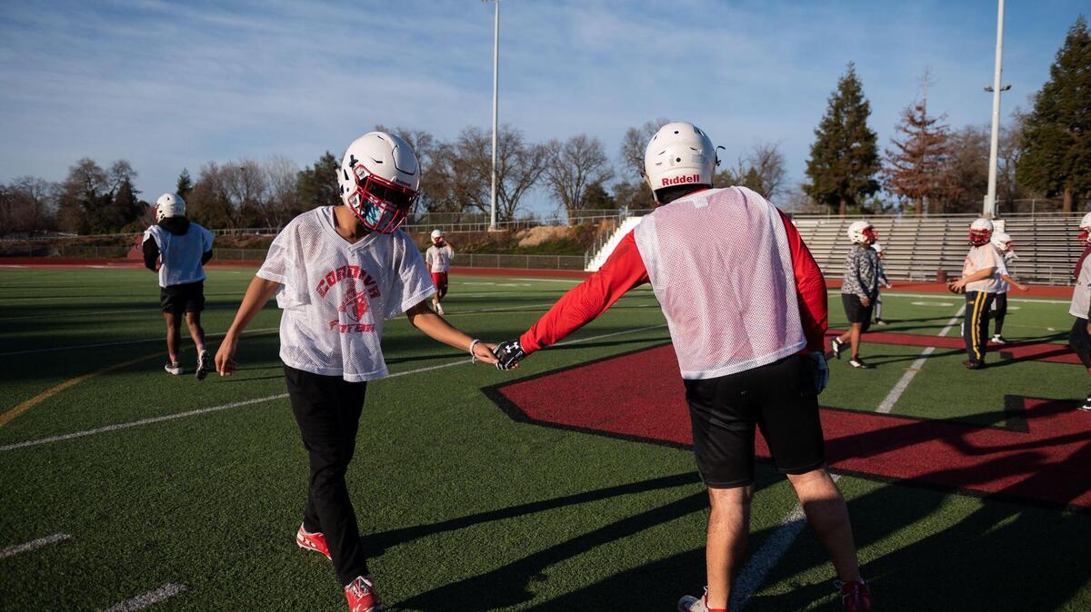 Cordova High School football teammates and tight ends Amandla Davis, left, fives Daniel Simonyan during practice Friday, Feb. 26, 2021, in Rancho Cordova as some sports return in area high schools.