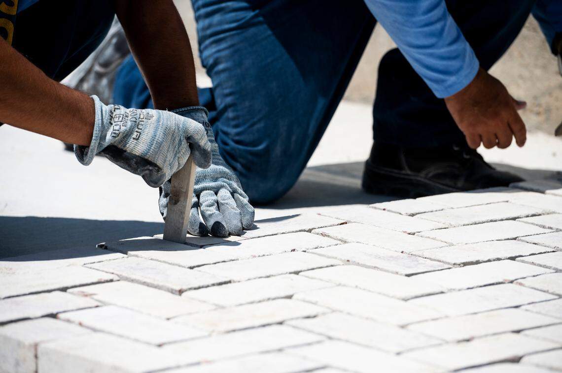 Inmates work to arrange and space brick pavers as part of the masonry vocational program at Valley State Prison. The facility offers training in trades ranging from plumbing to optics.