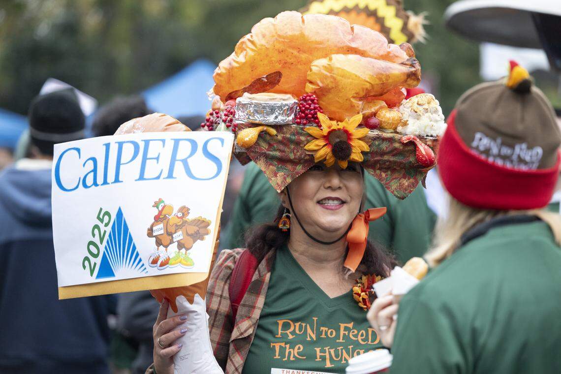 Hillary Sunada wears a hat decorated as a Thanksgiving table spread before the Run to Feed the Hungry in Sacramento on Thursday, Nov. 27, 2025.