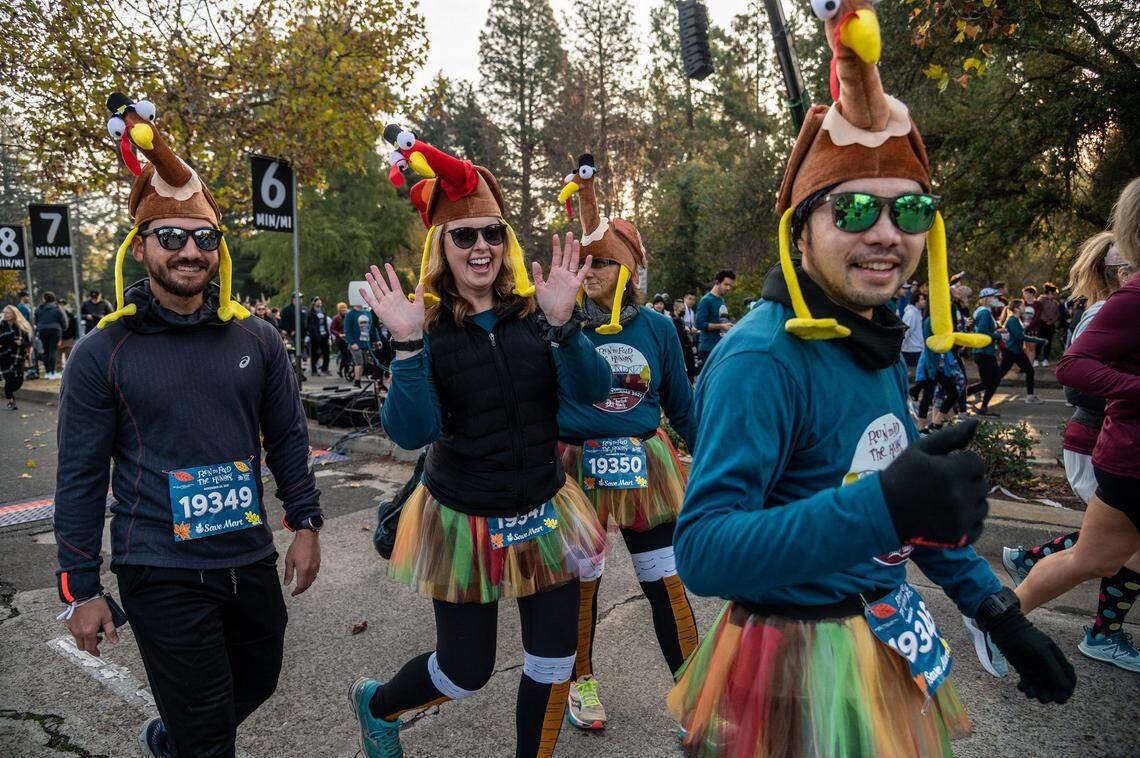 Mallory Yamagata, of Citrus Heights, waves as she celebrates Thanksgiving Day with her family at the 28th annual Run to Feed the Hungry on Thursday, Nov. 25, 2021.