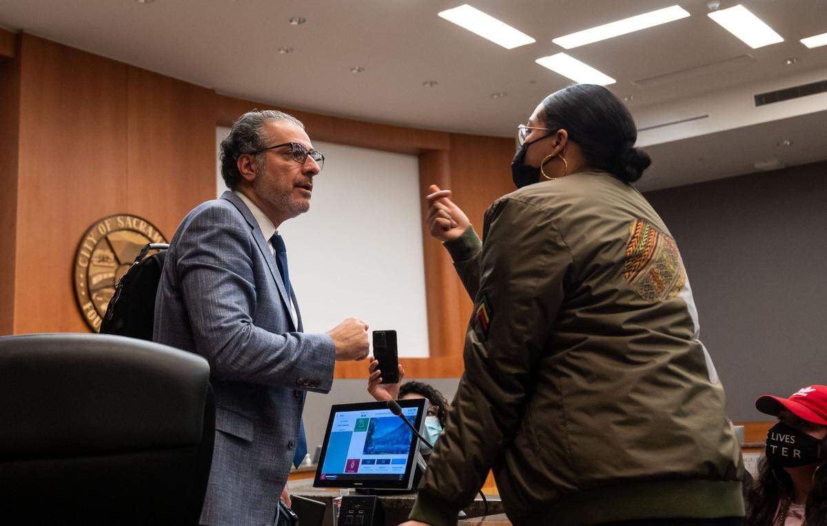 A Sacramento resident identified in public comment as MVW confronts Sacramento City Councilman Sean Loloee, left, after Tuesday’s meeting. MVW spoke against the Jan. 31 council vote to purchase the Rook earlier in the night. “Don’t show your face in Natomas, girl,” she said to newly elected Councilwoman Karina Talamantes. “Black and Brown boys are in Natomas, the boys you are now going to allow to be killed.”