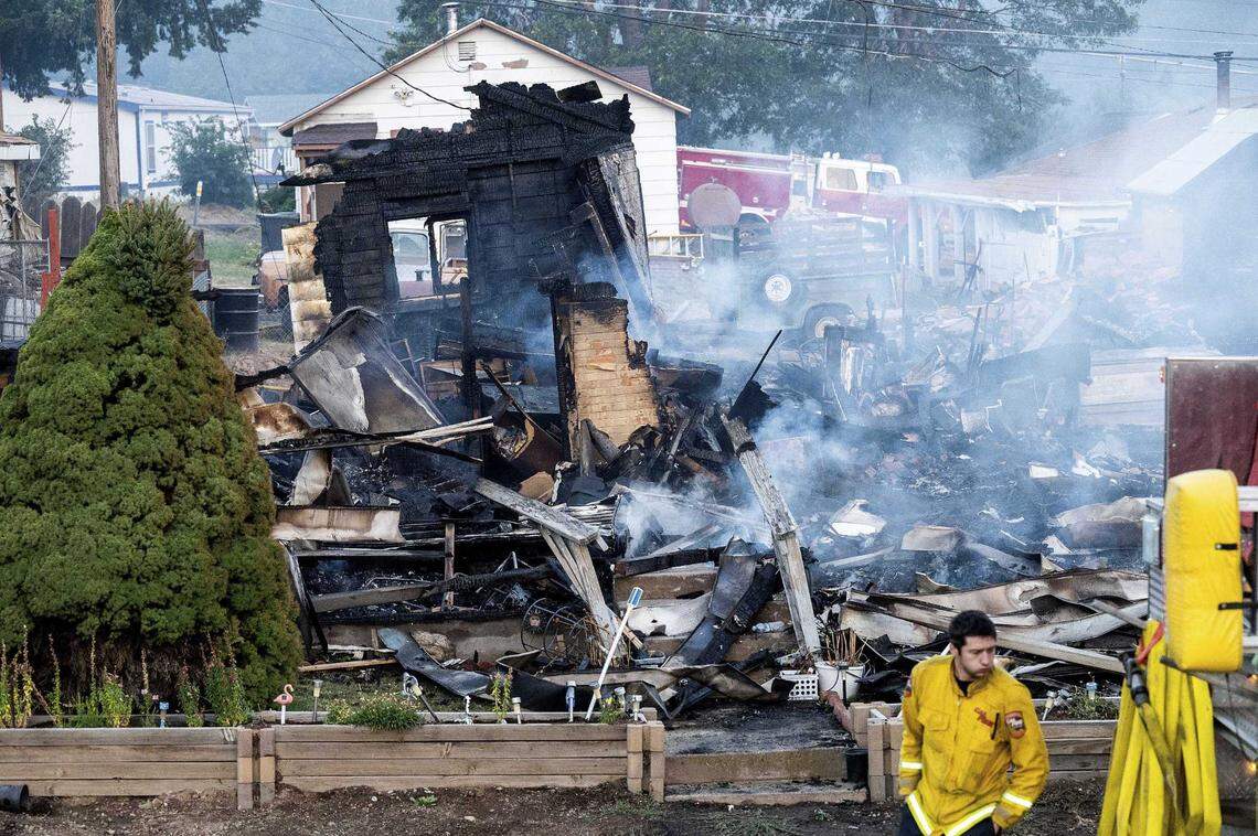 A firefighter passes a home destroyed by the Mill Fire on Sept. 3 in Weed.