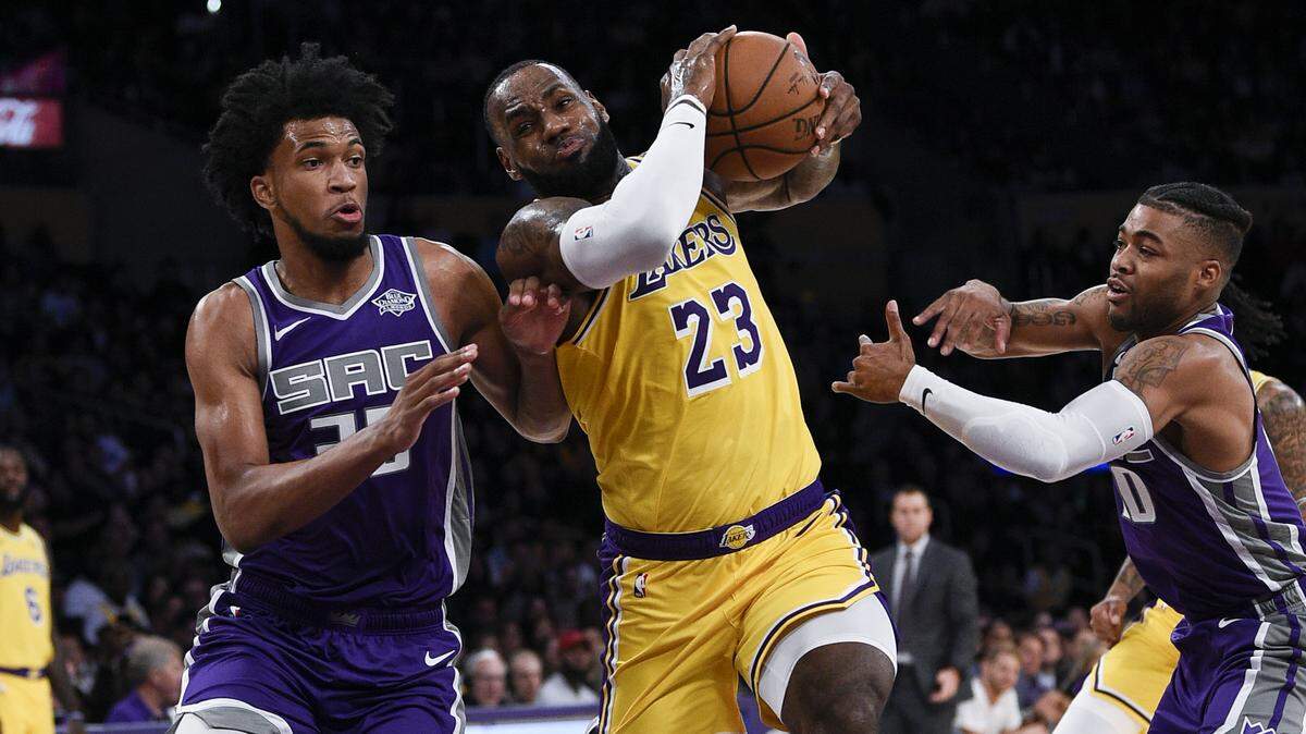 Los Angeles Lakers forward LeBron James, center, drives to the basket against Kings forward Marvin Bagley III, left, and guard Frank Mason III during a preseason game Oct. 4 in Los Angeles. James and the Lakers visit the Kings on Saturday night.