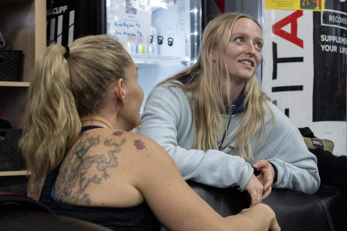 Michaela Mayer, right, talks with her friend Christina Rizzo at AnywhereFit Folsom on Monday. Mayer, who was recently diagnosed with brain cancer, is a CrossFit coach, and her gym community is coming together for a fundraiser event in her support.