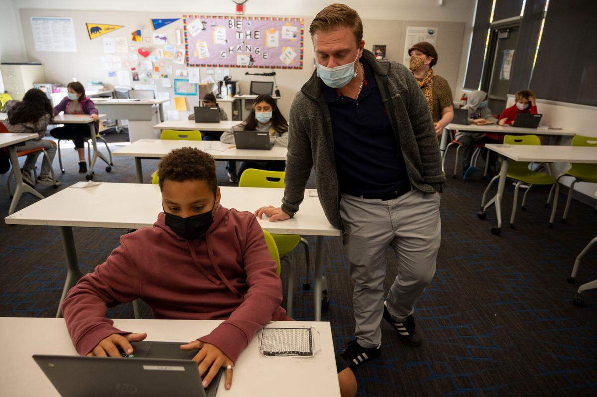 Substitute teacher Hank Pankratz helps Caleb Weddle, 11, in a sixth grade class at Sylvan Middle School in Citrus Heights in 2021. Enrollment dropped by 1,600 students in the past year in the San Juan Unified School District according to state data.
