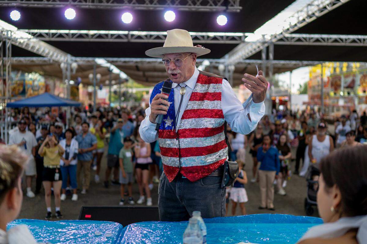 Dennis Forel explains the rules to participants of the pie eating contest at the California State Fair in Sacramento on Monday.