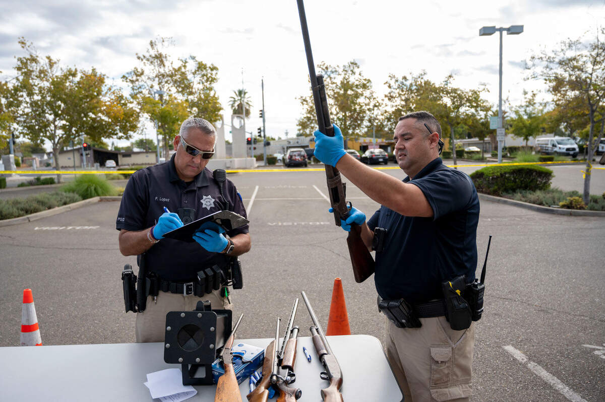 Sacramento Police officers Peter Lopez, left, and Frank Ley log in firearms at a gun buyback event on Saturday, Oct. 22, 2022, at the Sacramento Police Department headquarters. The Yolo County Sheriff’s Office will be holding a similar event on Aug. 26 in Davis.