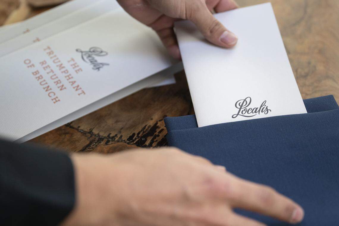 A member of the wait staff puts out menus in preparation for Localis’s return of brunch service at their restaurant in Sacramento on Sunday, Feb. 22, 2026. Barnum-Dann said, “Brunch is supposed to be casual. It’s still fine dining. It’s still what we do.” 