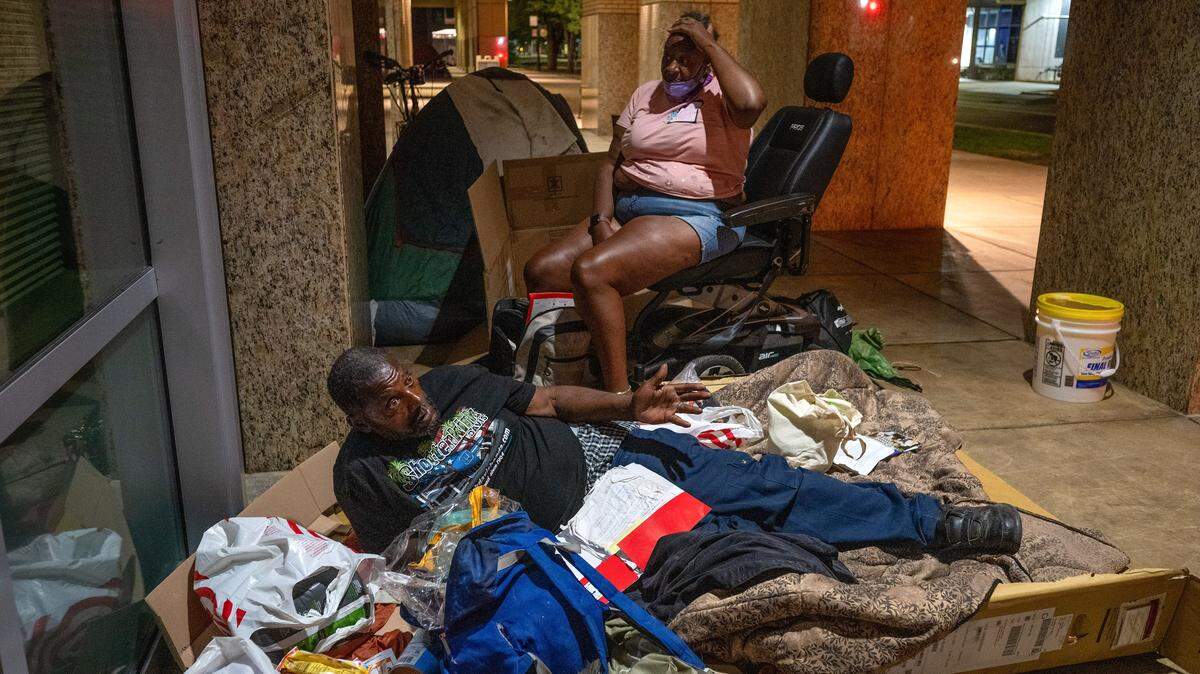 Under the lights of Sacramento City Hall, Gary Kelly, 68, and his partner of nine years, Xaveria Conley, 53, prepare to sleep on Tuesday, Aug. 19, 2025. New legislation would streamline the ability of providers to enroll homeless into comprehensive treatment and service plans.