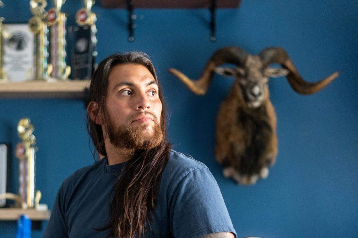 Jose Martinez sits near some trophies at his home in Apple Valley in August.