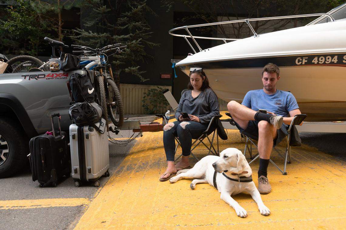 Samuel Stoddart and Sandra Figueroa wait for a room with their dog, Bella, their truck and their boat at Harrah’s Lake Tahoe casino in Stateline, Nevada, on Monday, Aug. 30, 2021, after a mandatory evacuation from their South Lake Tahoe home because of the Caldor Fire’s approach. They said they have been waiting at the hotel for 3 hours, after a two-hour drive over the short distance.