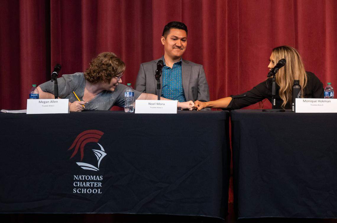 Natomas school board candidate Noel Mora sits between fist-bumping conservative candidates Monique Hokman and Megan Allen at an October candidate forum. Mora defeated Allen for the Area 1 seat, while Hokman lost to Cindy Quiralte in Area 4.