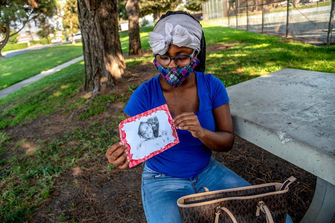 Daisha Watts, 19, glances at a picture showing her with her father Quinton Watts from a family trip to Chuck E. Cheese, while talking in Stockton in October about how close she felt to her father.