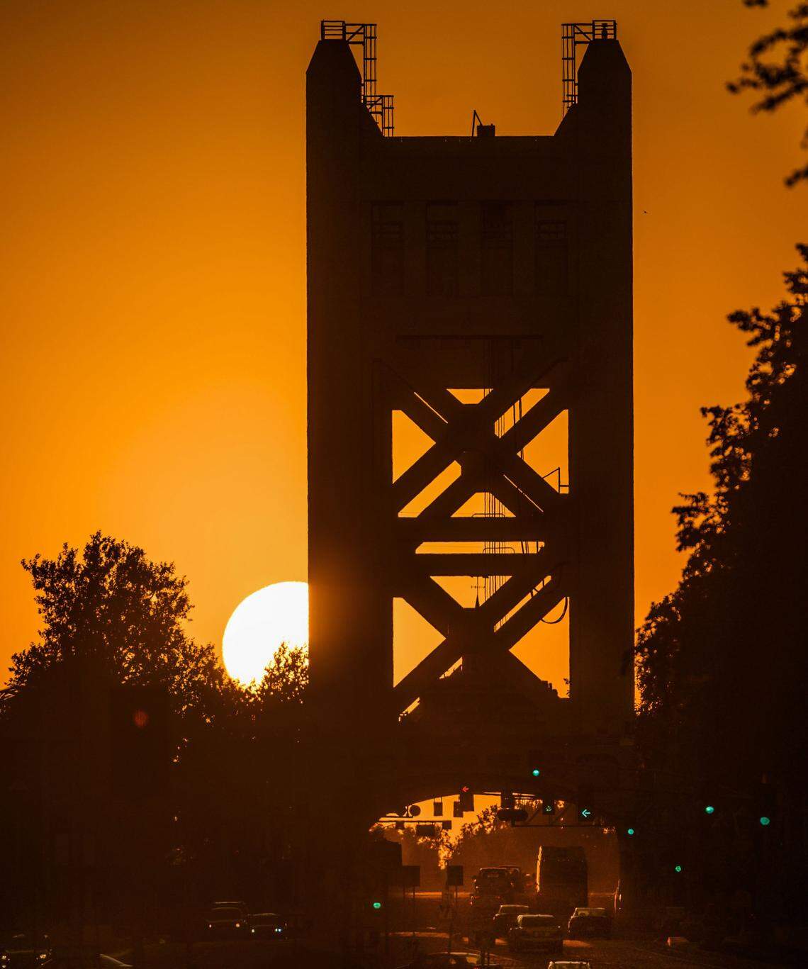 The sun sets near the Tower Bridge in downtown on Aug. 15, 2019, as temperatures climbed into the triple digits.