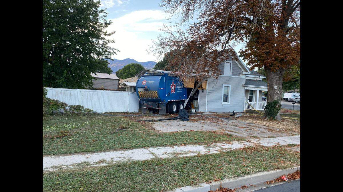 A garbage truck smashed through the side of a Utah home while three people were inside, authorities said. 