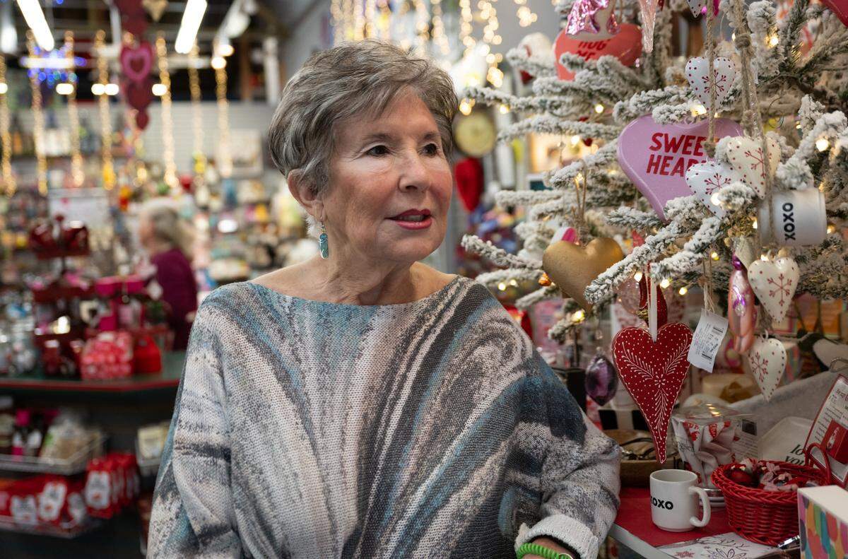 Owner Linda Novi, 77, stands near a tree of Valentine’s Day decorations in Mixed Bag, a beloved midtown Sacramento gift shop, on Thursday. She is ready to retire and plans to close the store after unsuccessful attempts to find a buyer. 