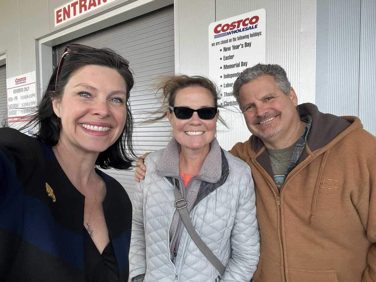 La concejala de Sacramento Lisa Kaplan (a la izquierda) sonriendo con los habitantes de Natomas Elena, de 52 años, y Dave Murphy, de 56, que esperaban en la fila del nuevo Costco el miércoles. La tienda abrió el jueves en la mañana.