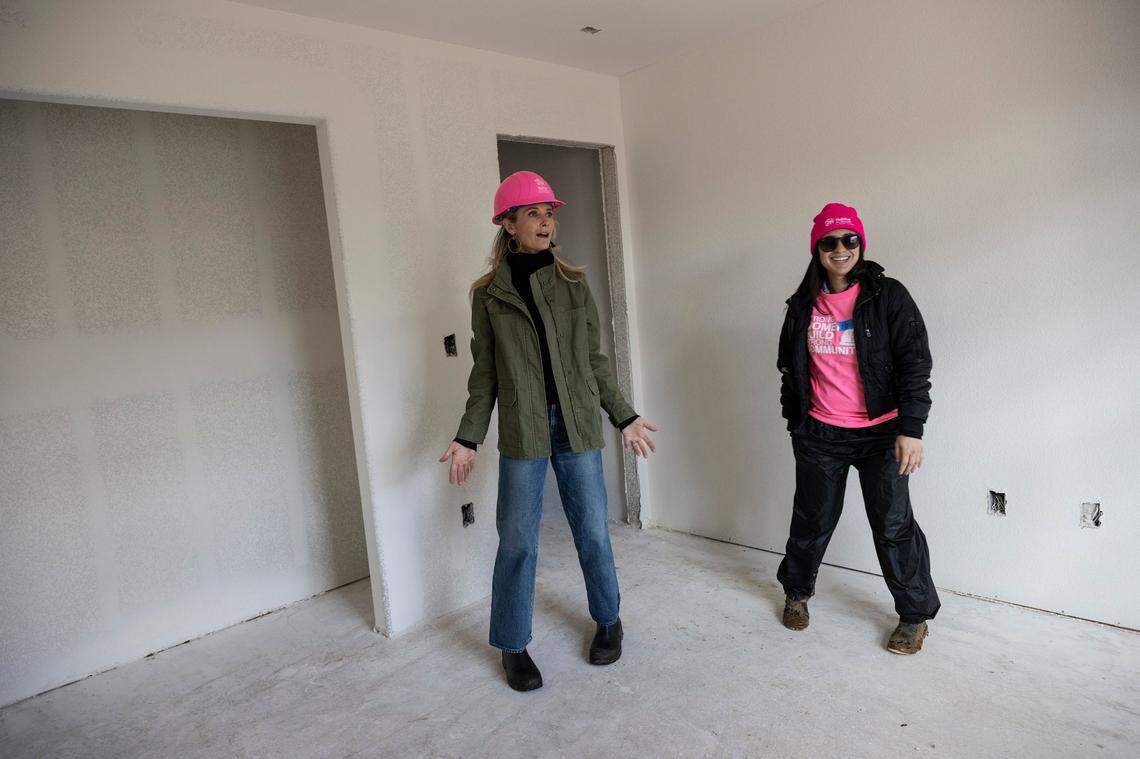 First Partner Jennifer Siebel Newsom reacts as she tours a house still under construction by Habitat for Humanity on Wednesday that belongs to Monique Lujan, right, a single mother with two children.