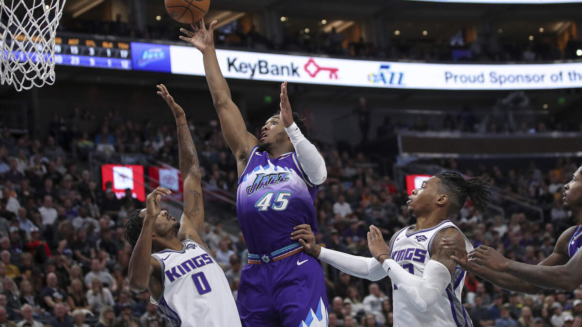 Utah Jazz guard Donovan Mitchell shoots the ball between Sacramento Kings forward Trevor Ariza and Sacramento Kings forward Richaun Holmes.
