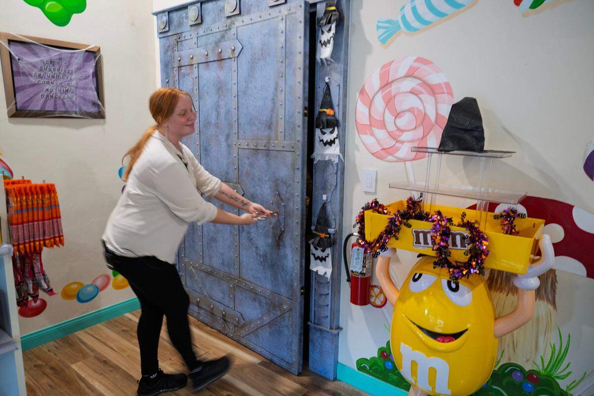 Sierra Gouvea unlocks the door to Daniello’s speakeasy, hiding inside Mikey & Madeline’s Candy Shoppe, after being told the secret password Friday.