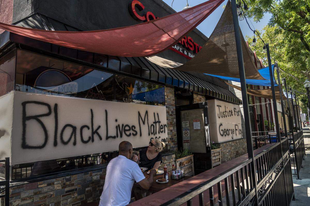 After several days of unrest customers have lunch at Cornerstone Cafe and Bar on J Street in Sacramento on Tuesday, June 2, 2020. Some businesses have show their support by posting signs in behalf of Black Lives Matter and Justice for the death of George Floyd, an unarmed black man, at the hands of a police officer in Minneapolis, Minnesota.