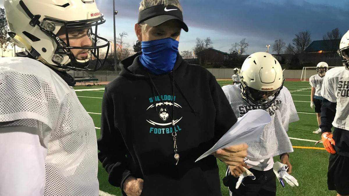 Sheldon football coach Chris Nixon goes over practice plays with his quarterback and son Sean Nixon.