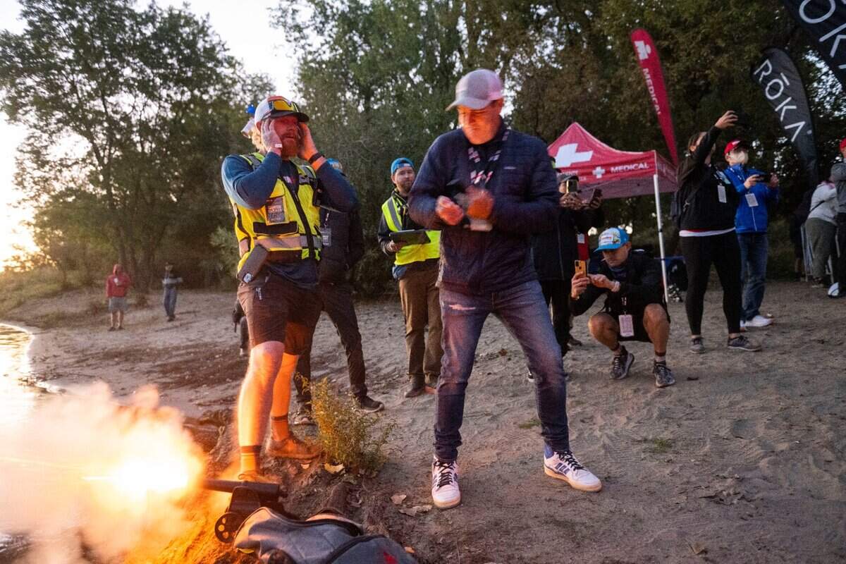 Mike Testa, president of Visit Sacramento, pulls on a string to start the Ironman California triathlon in Sacramento on Sunday, Oct. 23, 2022.
