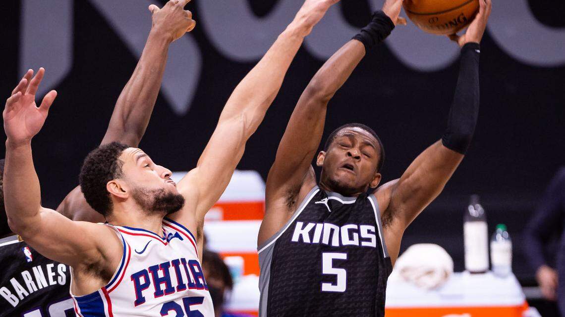 Sacramento Kings guard De’Aaron Fox (5), right, rebounds the ball over Philadelphia 76ers guard Ben Simmons (25) during the first half of the NBA game Tuesday, Feb. 9, 2021, at Golden 1 Center in Sacramento.
