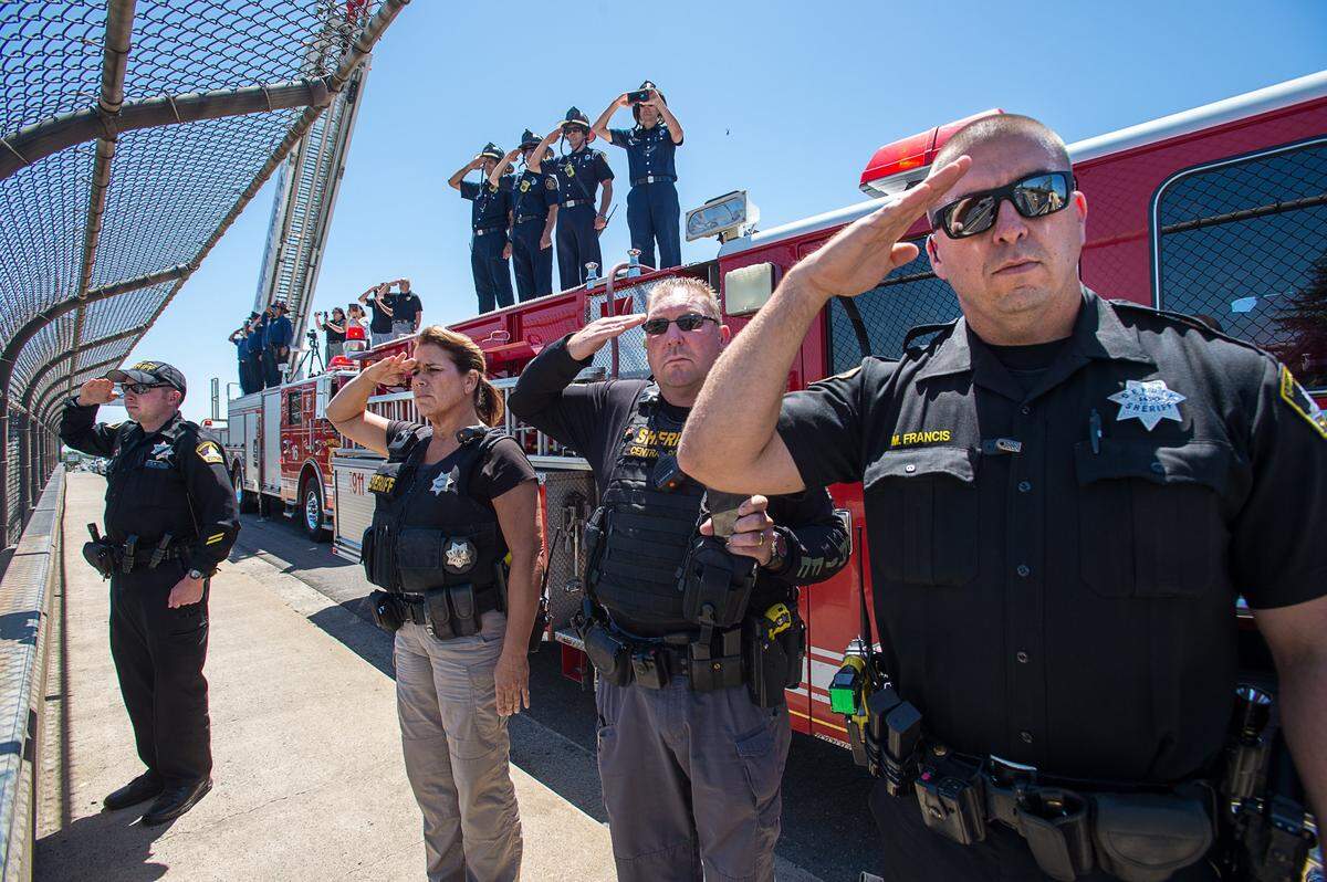 Sacramento Sheriff’s deputies, from left, Craig Bliss, Michelle Allen, J.W. Brookshire and Mark Francis salute as he honor procession for Sacramento police Officer Tara O’Sullivan drives down Highway 99 near Florin Road to the Herberger Funeral Home in Elk Grove on Friday, June 21, 2019.