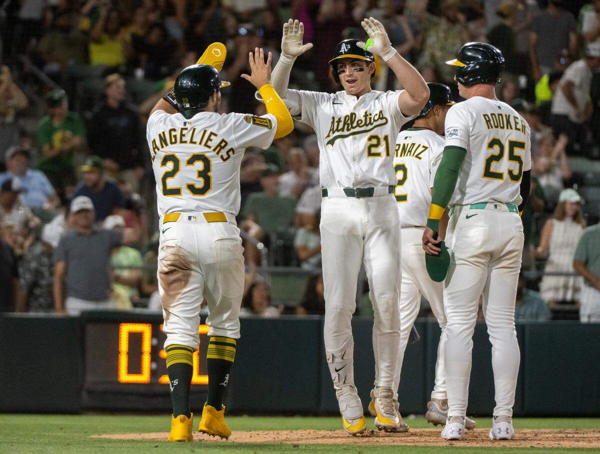 Athletics outfielder Tyler Soderstrom (21) celebrates with Shea Langeliers (23) and Brent Rooker (25) after his three run-home run in the seventh inning during a game at Sutter Health Park in West Sacramento on Monday.